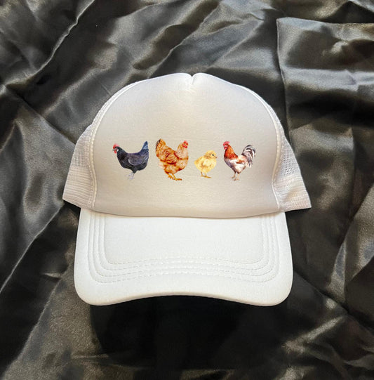 A white trucker hat is on a black background withe 4 different chicken images on the front of the hat